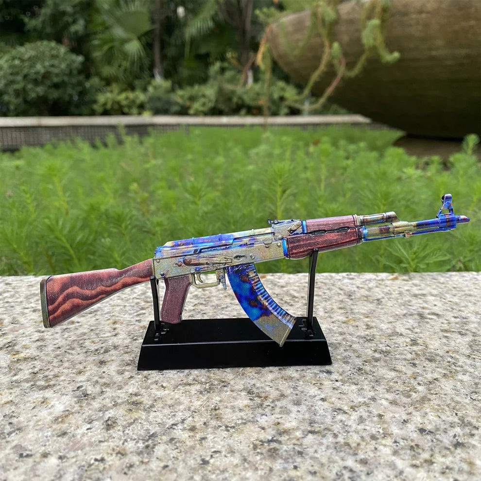 AK-47 Case Hardened replica on its black display stand in a garden