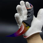 Karambit Fade trainer held in a gloved hand, finger through the ring
