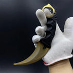 Karambit Lore trainer in a gloved hand, finger through the gold ring