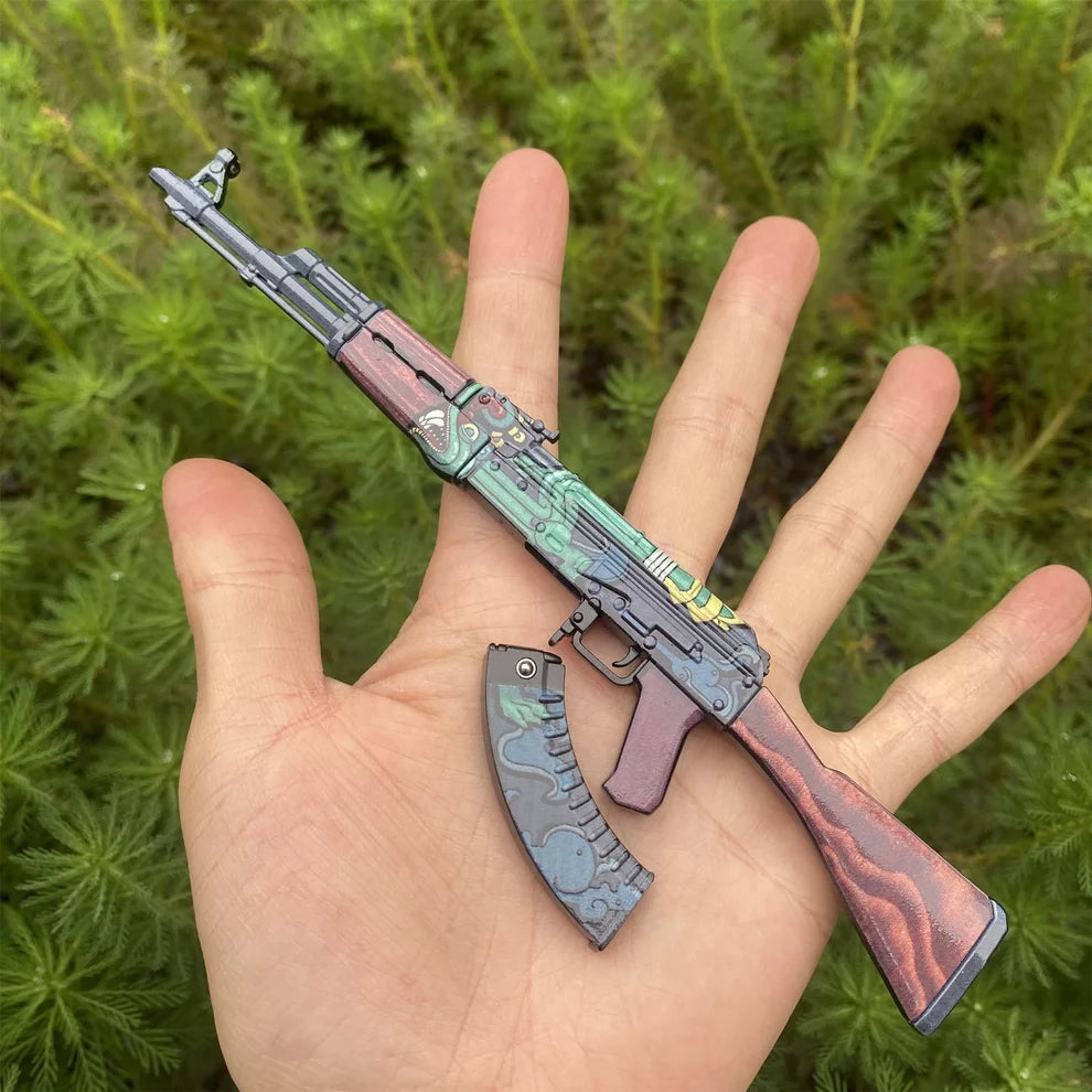 AK-47 Fire Serpent miniature in a hand with the magazine detached