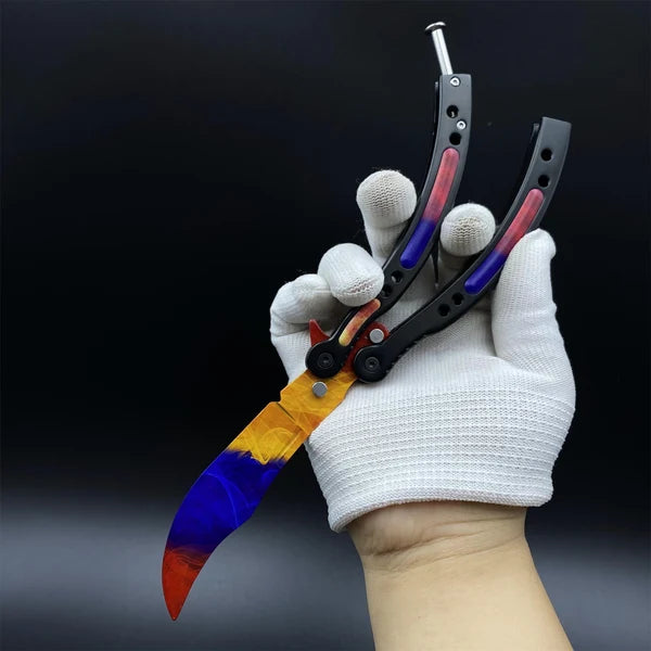 Butterfly Knife Marble Fade balisong trainer in a gloved hand, blade down